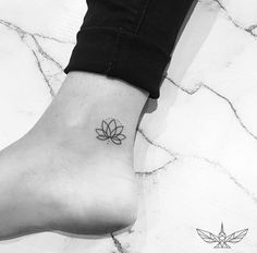 a small lotus tattoo on the ankle