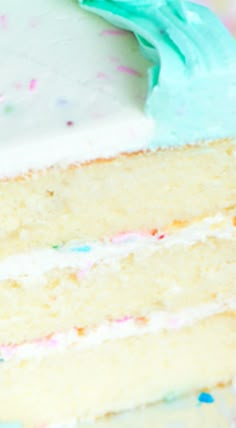 a slice of cake with white frosting and sprinkles