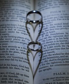 an open book with two wedding rings on it