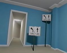 an empty room with blue walls and two white signs on the wall pointing in different directions