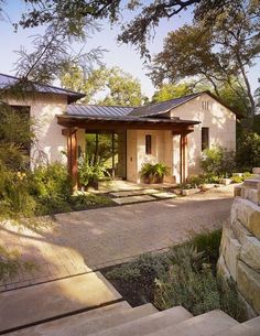 a house with stone steps leading up to the front door and entry way, surrounded by trees