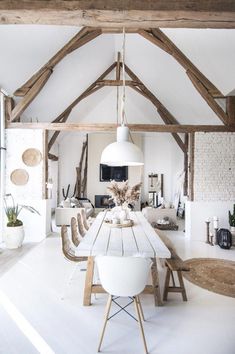 a white dining room with wooden beams and an open floor plan is seen in this image