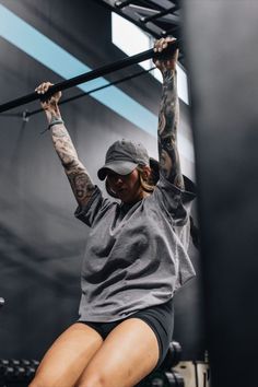 a woman doing squats on a bar in a gym