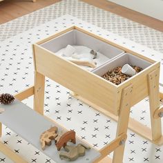 a wooden table with two trays filled with toys