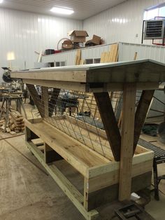 a bench made out of wood and wire in a building with lots of work on it