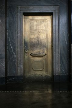 an old door is in the middle of a room with marble walls and flooring