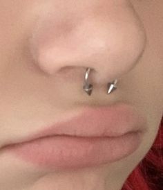 a woman's nose with two piercings on it