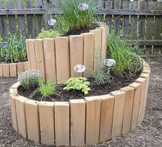 a circular wooden planter filled with lots of plants