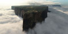 an aerial view of a cliff in the clouds