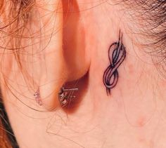 a woman's ear with a music note tattoo on it