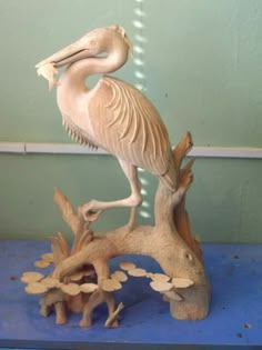 a statue of a pelican sitting on top of a tree stump in a room