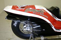 a red and white motorcycle parked in a garage