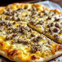 a close up of a pizza with cheese and sausage on it's crusts