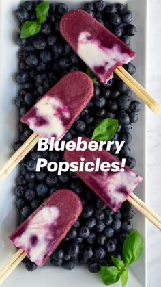 blueberry popsicles on a plate with basil leaves