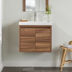 a bathroom vanity with a mirror above it and a wooden stool in front of it