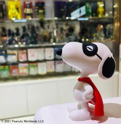 a small toy dog with a red scarf around its neck sitting on top of a table