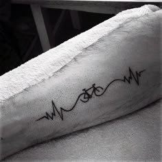 a close up of a person's arm with a heartbeat tattoo on the wrist