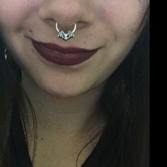 a close up of a woman with a nose ring on her nose and an antelope piercing