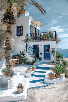 a white house on the beach with blue doors