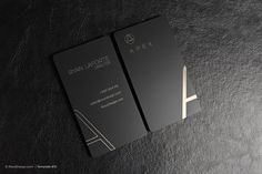 a black business card sitting on top of a leather surface with the letter a in gold