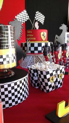 a table topped with lots of cakes and cupcakes next to each other on top of a red carpet