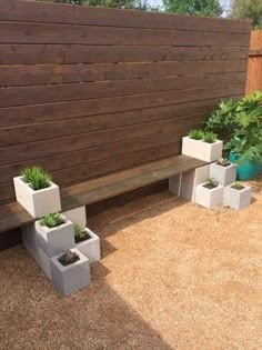 several cement planters are placed next to a wooden bench