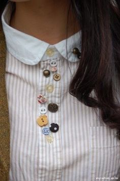 a close up of a person wearing a shirt with buttons on it