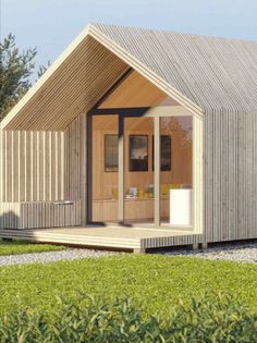 a small wooden house sitting on top of a lush green field