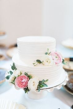 a white wedding cake with pink and white flowers