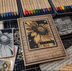 many different colored pencils are on the table next to some drawings and art supplies