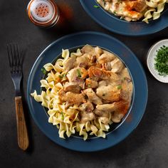 two plates of pasta with chicken and sauce