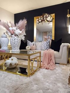 a living room filled with white furniture and lots of pink flowers on top of a table