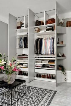 a living room filled with furniture and lots of closet space next to a white wall