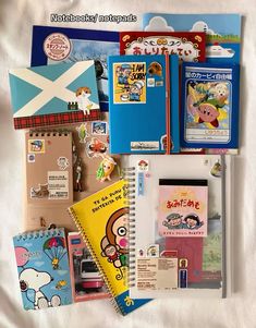 various children's books and stationery items laid out on a white sheet,