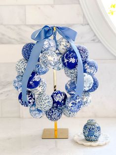 a blue and white ornament on a stand next to a cupcake holder