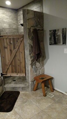 a bathroom with a stone shower and wooden bench