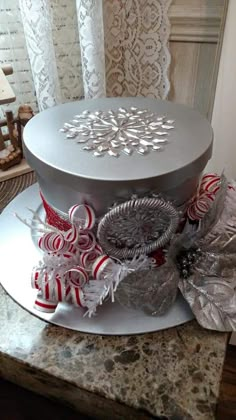 a silver hat with red and white decorations on it