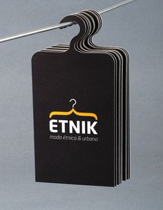 a stack of black business cards sitting on top of a metal rack with clothes pins sticking out of it