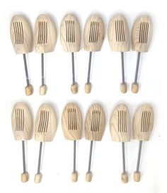 six wooden kitchen utensils are lined up on a white surface with pins in them