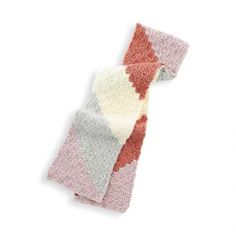 a knitted scarf on a white background with an orange and pink design in the middle