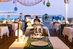 a restaurant with tables set for two and wine glasses on the table