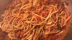 a pan filled with pasta and sauce on top of a stove