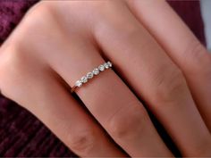 a woman's hand with a diamond ring on top of her finger and the bottom half