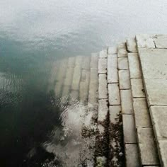 the water is very calm and there are steps leading up to the edge of the water