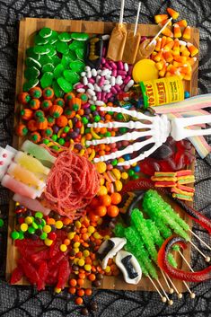 an assortment of halloween candy on a wooden tray