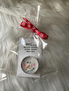 a white snowman ornament with a red ribbon