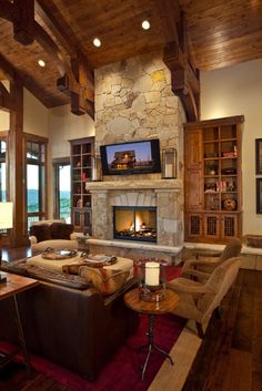 a living room with couches, chairs and a fire place in the middle of it