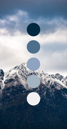 three circles are floating in the air above snow covered mountains