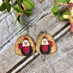 a pair of earrings with an image of a chicken on it