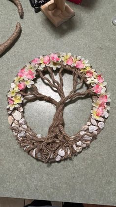 a tree made out of rocks and flowers on a table next to some other items